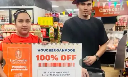 Pareja en Tulsa muestra su voucher ganador del 100 por ciento en La Cosecha Supermercado y celebra su compra gratis con alegría